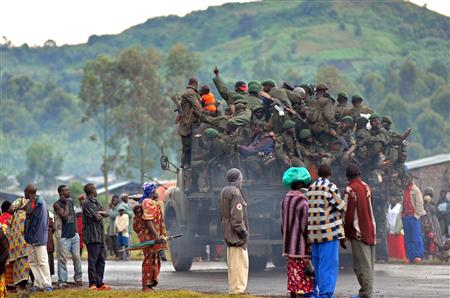 Cooperantes en el este de Congo estaban tratando de localizar y ayudar a miles de personas desplazadas por los combates después de que encontraran campos de refugiados vacios en zona rebelde, y sus ocupantes se desvanecieran entre los arbustos. En la imagen, un grupo de peronas observa un camión cargado de soldados congoleses a las afueras de Goma, el 2 de noviembre de 2008. REUTERS/Les Neuhaus